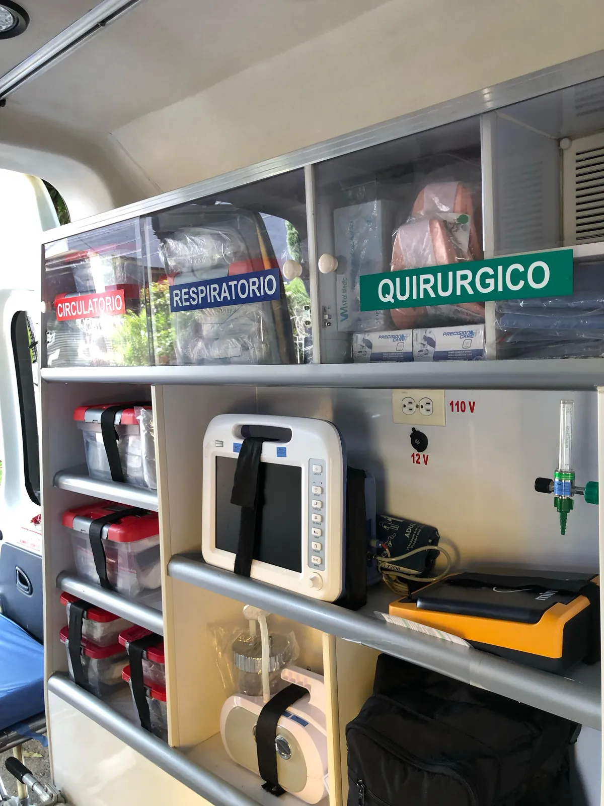 Gabinetes rotulados con equipos médicos dentro de una ambulancia de ARUM